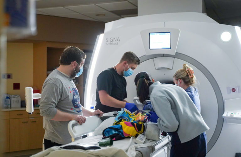Health care professionals working with a child during a medical imaging visit.