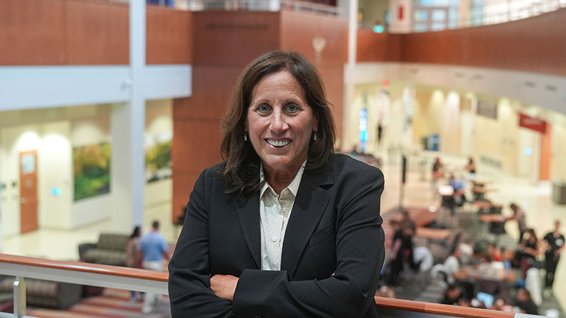 Dr. Mary Nevin is wearing a black blazer and posing for the camera with her arms crossed.