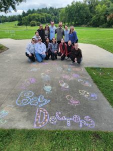 Residents standing in front of chalk art in a park