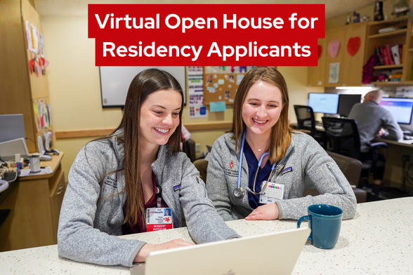 Two residents sitting in the resident lounge looking at a laptop. Virtual open house for residency applicants.