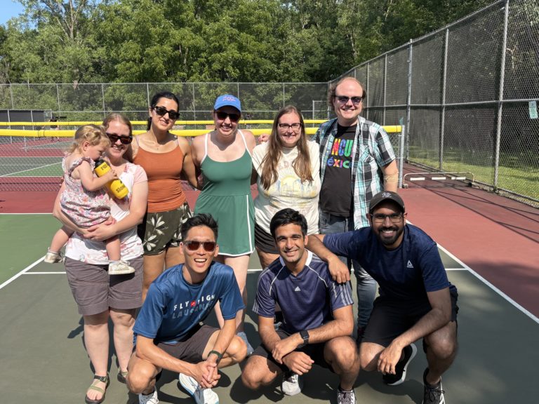 Residents posing for a photo on a tennis court