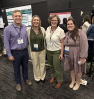 A group of four people standing together at a conference.