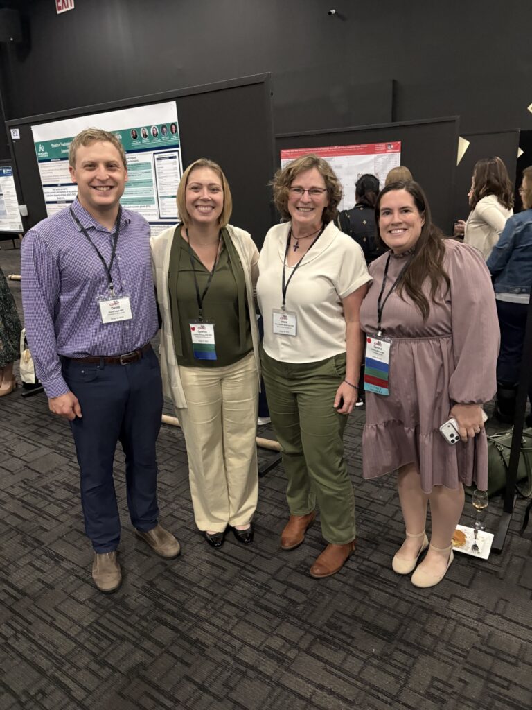 A group of four people standing together at a conference.