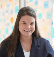 Dr. Brittany Lehrer standing in a glass hallway.